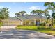 Charming single-story home featuring a three-car garage, lush landscaping, and a well-manicured lawn at 2196 Muskogee Trl, Nokomis, FL 34275