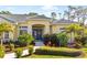 Inviting home featuring a blue double-door entry, lush tropical landscaping, and a well-manicured lawn at 2196 Muskogee Trl, Nokomis, FL 34275