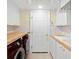 Functional laundry room with stainless steel appliances, white cabinets, and wood countertops at 2196 Muskogee Trl, Nokomis, FL 34275