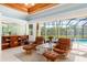 Comfortable living room features a beautiful wood ceiling, large windows, and poolside views at 2196 Muskogee Trl, Nokomis, FL 34275