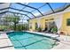 Private screened-in pool with elegant paving, landscaping, and sun loungers at 2196 Muskogee Trl, Nokomis, FL 34275