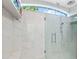 Luxurious walk-in shower with white marble-style tile, seating, and glass doors at 2196 Muskogee Trl, Nokomis, FL 34275