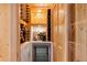 Custom wine room with racks, custom lighting, and beverage cooler at 2196 Muskogee Trl, Nokomis, FL 34275