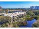 Panoramic aerial view of the condo complex with lush landscaping and a serene lake against a coastal backdrop at 225 Hourglass Way # 306, Sarasota, FL 34242
