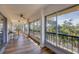 Spacious balcony with wood flooring and a view of lush tropical trees at 225 Hourglass Way # 306, Sarasota, FL 34242