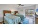 Bright bedroom with sliding glass door leading to balcony, and twin beds with decorative bedding at 225 Hourglass Way # 306, Sarasota, FL 34242