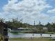 Scenic view from the condo overlooking a pond, lush greenery, and a clear sky at 2938 Clark Rd # 203, Sarasota, FL 34231