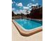 Large community in-ground pool with a black perimeter fence and lounge chairs at 2938 Clark Rd # 203, Sarasota, FL 34231