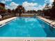 Community in-ground pool has a black fence for security and is surrounded by mature landscaping at 2938 Clark Rd # 203, Sarasota, FL 34231