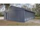 This home features a gray exterior with a side door and lush surrounding trees at 31860 Taylor Grade Rd, Duette, FL 34219