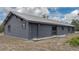 Exterior of home with modern gray siding, metal roof, gravel perimeter, and door access at 31860 Taylor Grade Rd, Duette, FL 34219