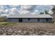 Rear home exterior showing sliding glass door, gray siding, and landscaping at 31860 Taylor Grade Rd, Duette, FL 34219