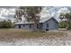 Yard view features the home, lush trees with Spanish moss, and modern metal roof at 31860 Taylor Grade Rd, Duette, FL 34219