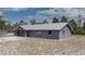 An exterior view shows the home's metal roof, xeriscaped front yard, and screened-in porch at 31860 Taylor Grade Rd, Duette, FL 34219