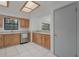 Well-lit kitchen featuring wood cabinetry, stainless steel appliances, and neutral countertops and tile flooring at 31860 Taylor Grade Rd, Duette, FL 34219