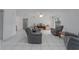 A spacious living room has tile floors, gray chairs, and a gray sofa at 31860 Taylor Grade Rd, Duette, FL 34219