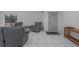 A living room has tile floors, gray chairs, a gray door, and a wooden side table at 31860 Taylor Grade Rd, Duette, FL 34219