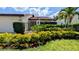 Charming single-story home features a well-manicured lawn, blooming flowerbeds, and black gated front porch at 3409 Montilla Ct # 8410, Sarasota, FL 34232