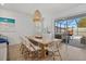 Dining area with a wooden table, woven chairs, and sliding glass doors leading to the pool area at 3443 74Th Avenue E Cir, Sarasota, FL 34243