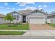 Beautiful home with a manicured lawn, brick driveway, American flag, and an attached garage at 3443 74Th Avenue E Cir, Sarasota, FL 34243