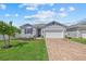 Attractive home featuring a lush green lawn, paved driveway, and convenient attached garage at 3443 74Th Avenue E Cir, Sarasota, FL 34243