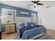 Relaxing bedroom featuring blue accent wall, plantation shutters, and a comfortable upholstered bed at 3443 74Th Avenue E Cir, Sarasota, FL 34243