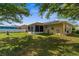 Exterior shot of the backyard, featuring a screened-in patio with lush green grass at 3459 Lotus Rd, North Port, FL 34291