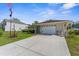 Inviting single-story home with an attached two-car garage and well-manicured front lawn at 3459 Lotus Rd, North Port, FL 34291