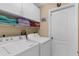 Bright laundry room with washer, dryer, shelving and cabinet at 3459 Lotus Rd, North Port, FL 34291