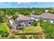 A high angle shot shows the home with mature trees, landscaping and large screened-in pool and patio at 3519 Founders Club Dr, Sarasota, FL 34240