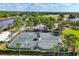 Scenic aerial view showcasing the tennis courts, lush greenery, and the serene lake in the community at 3519 Founders Club Dr, Sarasota, FL 34240