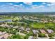 Aerial view of a neighborhood featuring a golf course, ponds, and lush green trees at 3519 Founders Club Dr, Sarasota, FL 34240