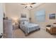 This carpeted bedroom features a ceiling fan, beach themed art and a cozy sitting area at 3519 Founders Club Dr, Sarasota, FL 34240