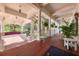 Inviting clubhouse porch featuring wooden floors, white columns, and lush landscaping at 3519 Founders Club Dr, Sarasota, FL 34240