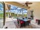 Screened lanai with outdoor dining area overlooking pool and wooded landscape at 3519 Founders Club Dr, Sarasota, FL 34240