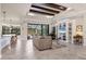 Spacious living room with tile floors, coffered ceiling, built-in shelving, and access to outdoor living area at 3519 Founders Club Dr, Sarasota, FL 34240