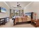 Spacious main bedroom features a tray ceiling, large windows with backyard views, and comfortable seating at 3519 Founders Club Dr, Sarasota, FL 34240