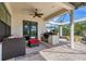 An elegant outdoor living space with a built-in kitchen, ceiling fan, and covered patio at 3519 Founders Club Dr, Sarasota, FL 34240