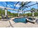 The relaxing screened-in pool includes a spa and is surrounded by lush landscaping and lounge chairs at 3519 Founders Club Dr, Sarasota, FL 34240