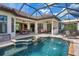 Enjoy this home's beautiful pool with a spa, covered patio, and screened-in enclosure at 3519 Founders Club Dr, Sarasota, FL 34240