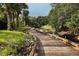 Picturesque wooden walking path meandering through lush greenery and along a tranquil creek at 3519 Founders Club Dr, Sarasota, FL 34240
