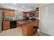 The kitchen features warm wood cabinetry and black appliances at 3740 Pinecone Ct # 163, Sarasota, FL 34238