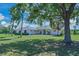 Spacious home with manicured lawn and mature trees, providing shade and curb appeal at 4412 Wolf Ridge Xing, Parrish, FL 34219