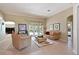Bright living room with tile flooring, comfortable seating, and access to outdoor pool area at 4412 Wolf Ridge Xing, Parrish, FL 34219