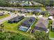 An aerial view of a home featuring a screened-in pool, solar panels and well maintained landscaping near a pond at 4509 95Th E Ter, Parrish, FL 34219