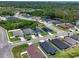 An aerial view of the property within a community, highlighting the screened pool and proximity to a pond at 4509 95Th E Ter, Parrish, FL 34219