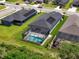 An aerial view showcasing the home's screened-in pool and manicured lawn within a suburban setting at 4509 95Th E Ter, Parrish, FL 34219