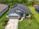 Aerial view of single-Gathering home featuring a gray two-car garage, well manicured lawn and landscaping at 4509 95Th E Ter, Parrish, FL 34219
