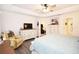 Bright main bedroom with a tray ceiling, seating area, neutral walls, and wood flooring at 4509 95Th E Ter, Parrish, FL 34219