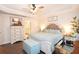 Bright bedroom with ceiling fan, tray ceiling, wood-look floors, and ensuite bathroom at 4509 95Th E Ter, Parrish, FL 34219